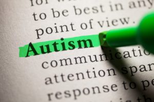 Un evidenziatore mette in risalto la parola “autism” in un testo scritto.
