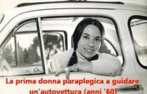 L’immagine divenuta una sorta di icona di Gabriella Bertini, che negli Anni Sessanta – come reca la stessa dicitura sotto la foto – fu la prima donna italiana in carrozzina a guidare l’automobile.