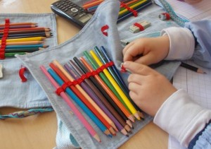 Le mani di un bambino ripongono le matite nell’astuccio.