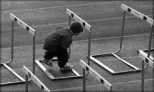 Un bambino effettua un percorso nel quale gli ostacoli lo costringono a procedere chinandosi. 