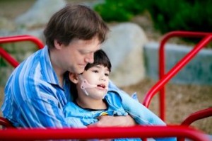 Un caregiver familiare insieme al figlio, persona con grave disabilità.