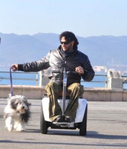Un uomo con disabilità motoria porta a spasso il suo cane.