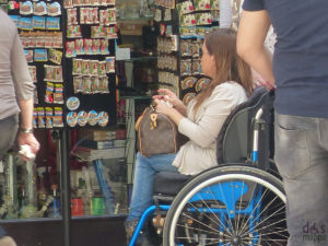 Una ragazza con disabilità motoria in un negozio di souvenir.