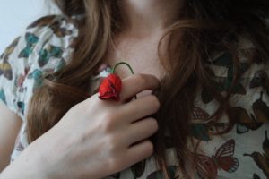 Particolare di una donna che tiene in mano una rosa appassita. (foto di Giulia Bertelli) 