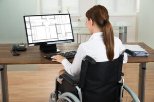 Una giovane donna con disabilità lavora al computer.