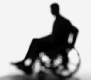 Immagine sfuocata di una persona in sedia a rotelle.