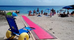 Una spiaggia dotata di diversi accorgimenti di accessibilità (una passerella per arrivare al mare, ed una sedia per consentire alle persone con disabilità motoria di entrare in acqua).
