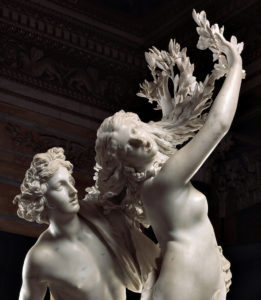 Gian Lorenzo Bernini, “Apollo e Dafne” (particolare), gruppo scultoreo in marmo, 1622-1625. L’opera rappresenta il mito di Dafne che, pur di sfuggire alla violenza di Apollo, si trasforma in un albero d’alloro. L’artista ritrae Dafne nel momento della metamorfosi. Apollo cerca di trattenerla cingendole la vita con una mano, ma lei tenta di divincolarsi protraendo le braccia di lato mentre sulle mani e tra i capelli germogliano tenere foglie di alloro. Sul suo volto un’espressione di dolore e stupore sottolineata dalla bocca aperta.