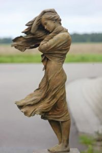 Una realizzazione in bronzo della scultrice cinese Luo Li Rong ritrae, con stile rinascimentale attento al dettaglio, una giovane donna i cui capelli ed il vestito leggero sembrano mossi dal vento.