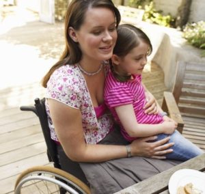 Una mamma con disabilità motoria con sua figlia di cinque/sei anni.