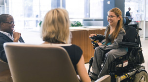 Una donna con disabilità motoria partecipa ad un incontro di lavoro.