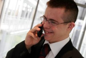 Un giovane con la sindrome di Down, in giacca e cravatta, mentre telefona.