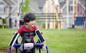 Un bambino con disabilità motoria in un parco.