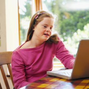 Una ragazza con sindrome di Down mentre utilizza un computer.